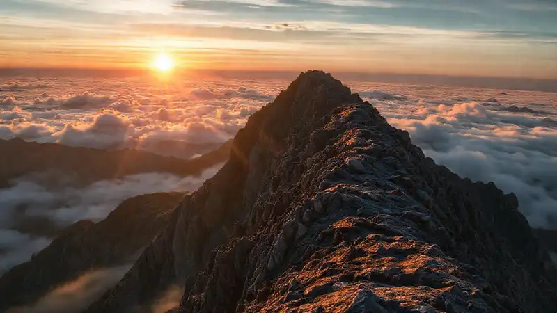 Persona escalando montaña con determinación y esfuerzo